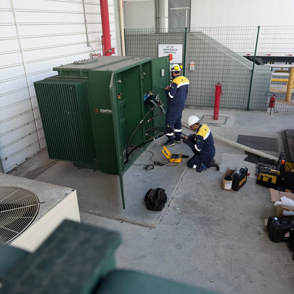 Técnicos realizando manutenção preventiva em transformador elétrico industrial